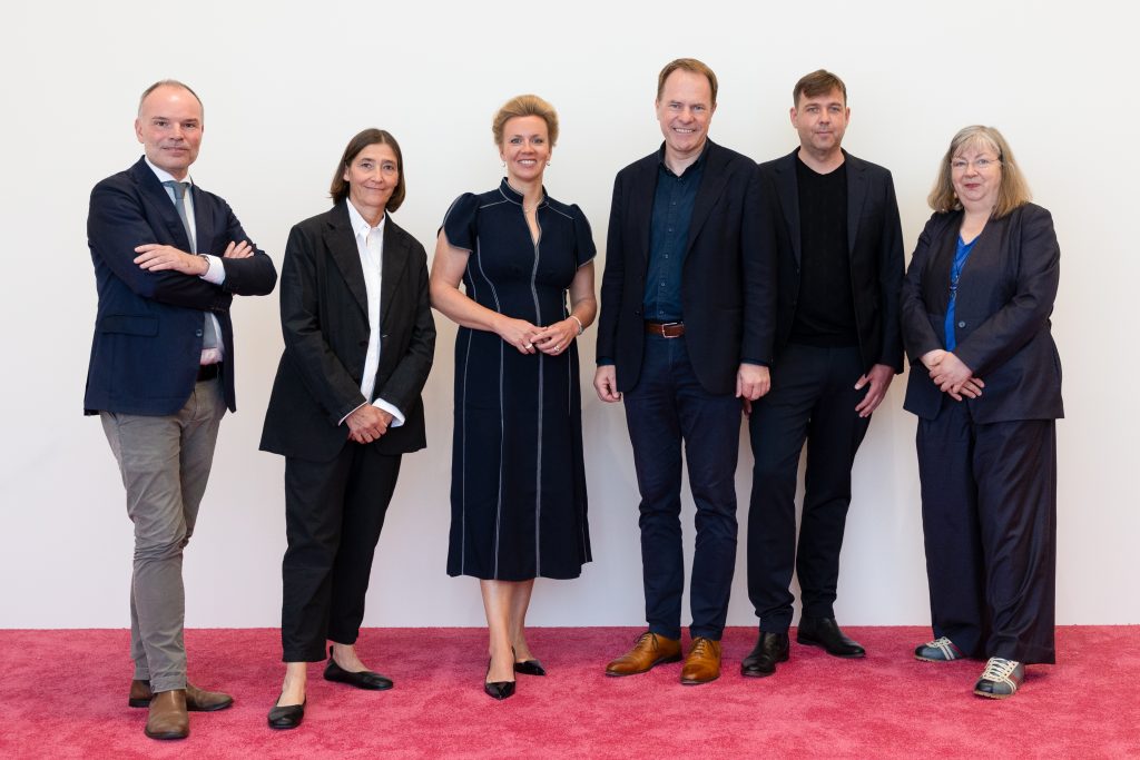  Teilnehmer aus Politik und Gründungskommission zur Pressekonferenz am 21. Juli 2025 in Düsseldorf. v.l.n.r.: Prof. Peter Gorschlüter (Direktor des Museum Folkwang), Prof. Dr. Susanne Gaensheimer (Di-rektorin der Kunstsammlung NRW), Ina Brandes (Ministerin für Kultur und Wissenschaft des Landes Nordrhein-Westfalen), Dr. Stephan Keller (Oberbürgermeister Düsseldorf), Moritz Wegwerth (Künstler und Fotograf, Vorsitzender DFI e. V.), Inka Schube (Kuratorin, Sprengel Museum)